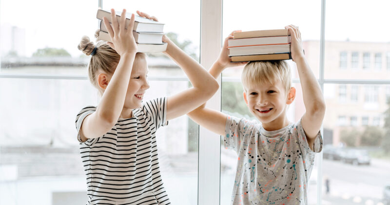 Stellenanzeige Buchhalter zwei Kinder die Buch über Kopf halten
